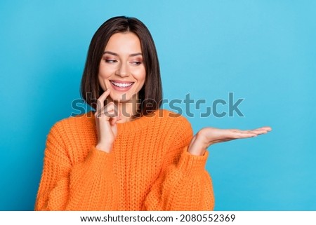 Portrait of attractive cheerful girl holding on palm copy space choosing idea isolated over bright blue color background Foto d'archivio © 