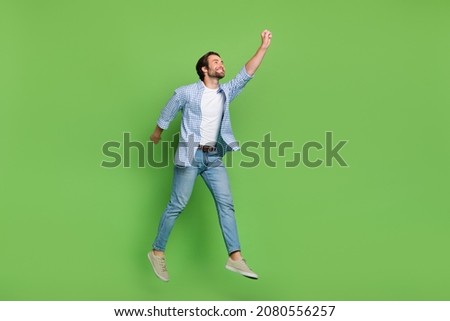 Full length profile side photo of young guy try to catch parasol look empty space jump isolated over green color background Stock foto © 