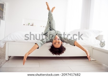 Portrait of attractive cheerful girl lying in bed having fun upside down good mood day at light home house indoors Foto stock © 