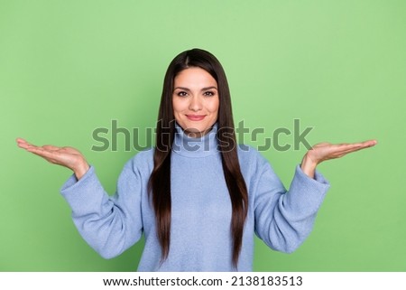 Photo of sweet shiny mature lady dressed blue pullover comparing arms empty space smiling isolated green color background Foto stock © 