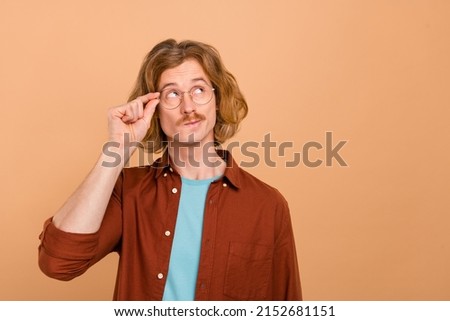 Portrait of attractive minded red-haired guy touching specs deciding copy blank space isolate over beige pastel color background Photo stock © 