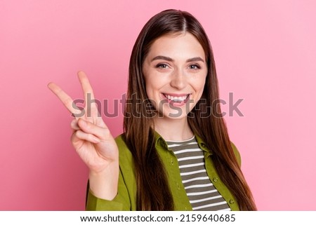 Photo of young adorable good mood female showing v-sign meet her friends say hi isolated on pink color background Stock fotó © 