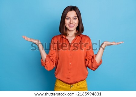 Photo of young pretty lady promoter hold hands solutions scales compare measure advertise isolated over blue color background Сток-фото © 