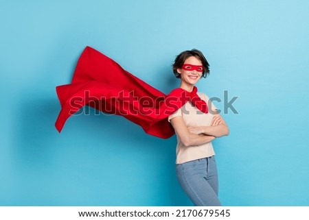 Photo of confident shiny lady dressed red mantle arms crossed cape flying isolated blue color background Foto d'archivio © 