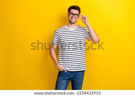 Photo of cheerful young man hand touch glasses toothy smile isolated on yellow color background Foto stock © 