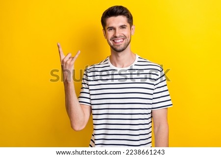 Photo of cheerful positive man arm fingers show heavy metal symbol toothy smile isolated on yellow color background Foto stock © 