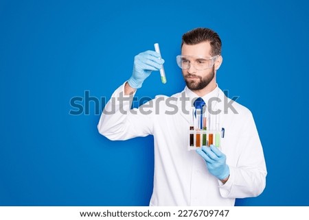 Similar – Image, Stock Photo Serious chemist examining liquid in flask in lab