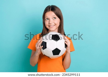 Cheerful preteen girl goalkeeper teasing rival on football field at sports stadium