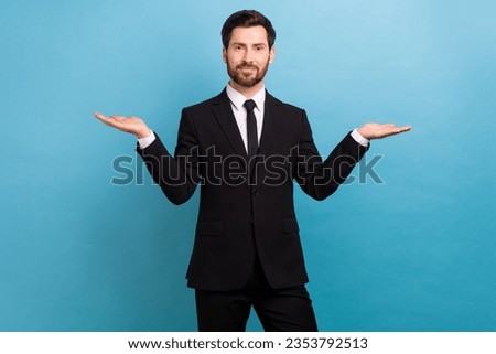 Photo of happy smiling clerk wear black tuxedo comparing arms empty space isolated blue color background Foto stock © 