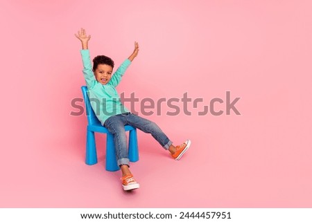 Similar – Image, Stock Photo A cheerful boy with a phone in his hands is sitting in a chair and playing a game or watching cartoons.