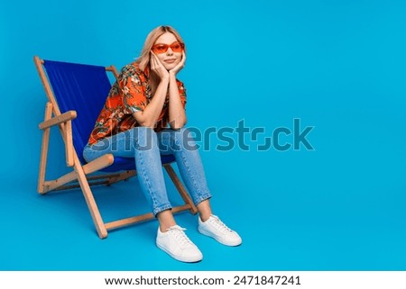 Image, Stock Photo Funny joyful blonde woman having fun while posing against blue studio wall, playing with strand of hair