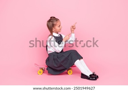 Foto Bild Kinderskateboardfahrer, der auf seinem Skateboard sitzt.