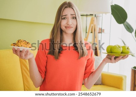 Foto Bild Skeptisches Mädchen isst Obst im Garten