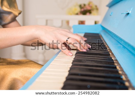 cropped image of the girl\'s hands on the piano keys. Close up of the hands of a young woman playing piano