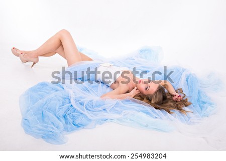 beautiful girl lies on plume of her long dress