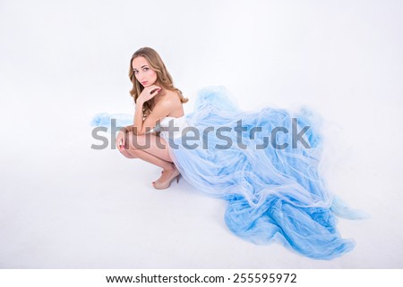 girl in a  long dress with plume on a white background