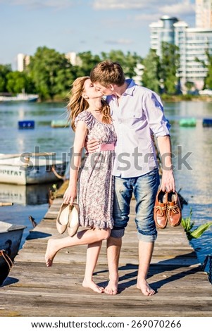 couple in love are on a wooden pier near the boat. Man and woman kiss on the dock