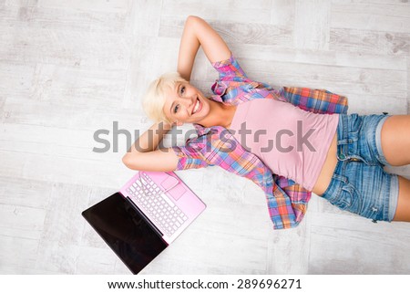 Top view of beautiful young woman lying on the floor and smiling