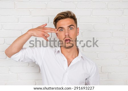 man portrays with his fingers gun to his temple