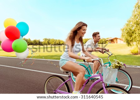 couple in love  riding a bicycle race with balloons