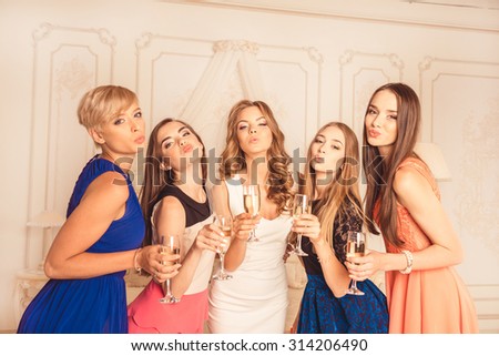 Bride with bridesmaids pouting lips with glasses