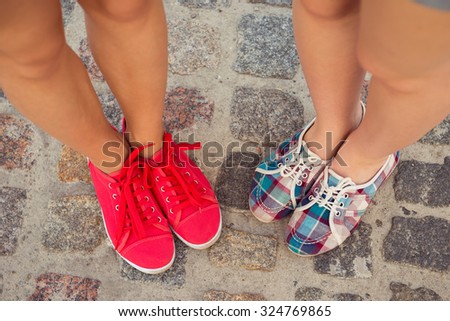 top view of a two pairs of sneakers shoes walking on paving ston