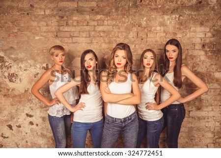 Confident serious young women with red lips wearing dress code