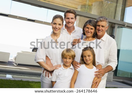 Six person family portrait in the backyard of a luxury house, jumping.