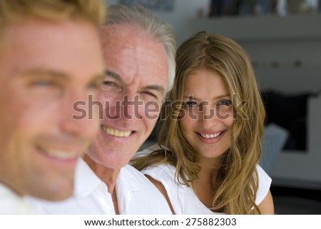 Portrait of senior man with his son and daughter-in-law (or daughter) side by side.