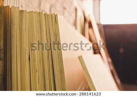 Stack of plywood in workshop. No people on photo. Industrial background of warehouse