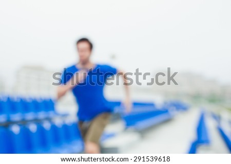 Blurred runner on a stadium running fast between chairs in urban landscape with white sky. Sport and healthy lifestyle in city concept. Toned image