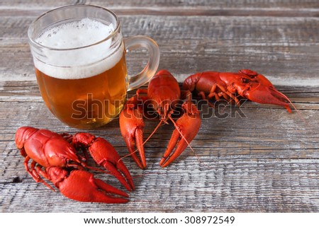 boiled crayfish and beer mugs on a wooden background