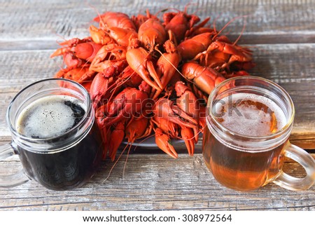 boiled crayfish and beer mugs on a wooden background