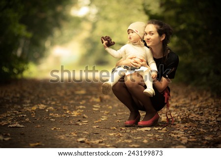 Adorable toddler girl playing with fashion Mom in the park. Autumn. Magic beauty natural back light