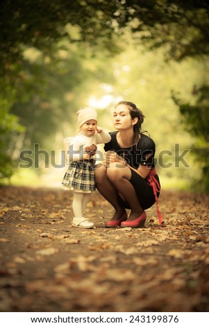 Adorable toddler girl playing with Mom in the park. Autumn. Magic beauty natural back light