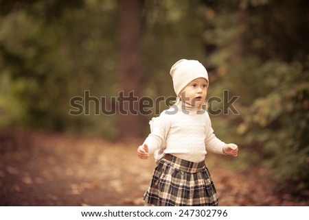 Adorable toddler girl lost in the forest. Autumn. Running. Finding the way out. Background forest.