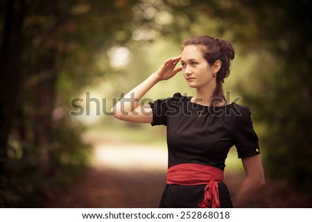 Fashionable woman in the forest. Magic beauty back natural light. Bright red belt
