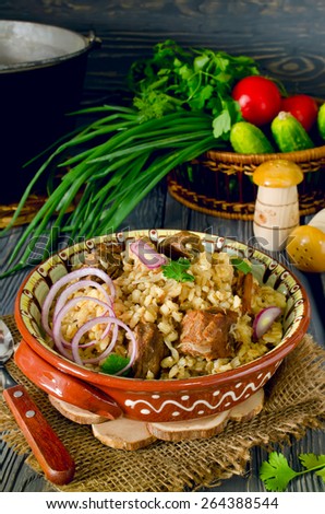 Pearl barley with meat on a wooden table, rustic style