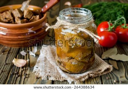 Canned meat in a glass jar on a wooden table