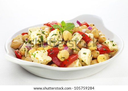 A salad of chickpeas, feta cheese, tomatoes, onion, lemon vinaigrette and herbs.