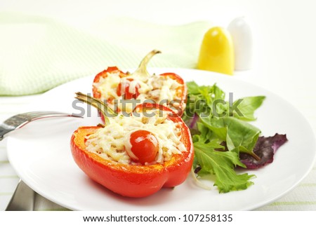 A red pepper halved and stuffed with rice, tuna and tomatoes, topped with cheese, and baked.