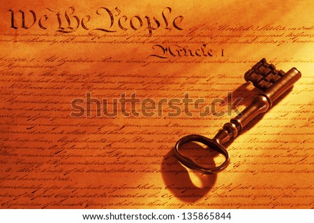 Beautiful old key on a copy of the US constitution with warm tungsten light.