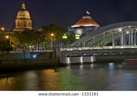 Singapore Parliament and Elgin Bridge lit up at night and reflected in the Singapore River