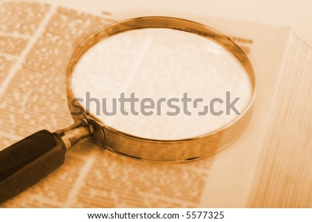 Magnifying glass over book, with blank space for your own text.