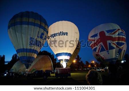 NORTHAMPTON, ENGLAND - AUGUST 18: Hot Air Balloons demonstrating night time glows at the Northampton Balloon Festival, on August 18, 2012 in Northampton, England.