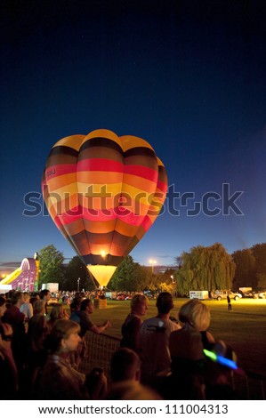 NORTHAMPTON, ENGLAND - AUGUST 18: Hot Air Balloon glowing brightly for night show at the Northampton Balloon Festival, on August 18, 2012 in Northampton, England.