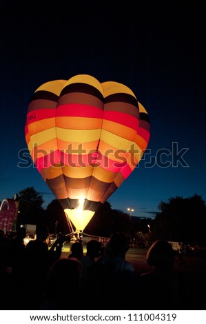 NORTHAMPTON, ENGLAND - AUGUST 18: Hot Air Balloon glowing brightly for night show at the Northampton Balloon Festival, on August 18, 2012 in Northampton, England.
