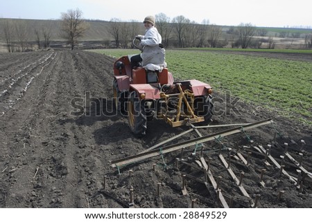 farmer on mini tractor processes field