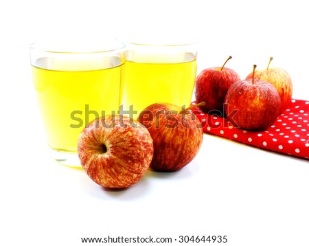 red apples and glass of fresh apple juice over white background