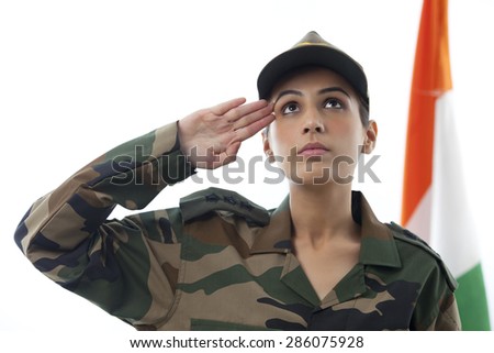 Female soldier saluting while looking up and Indian flag in background